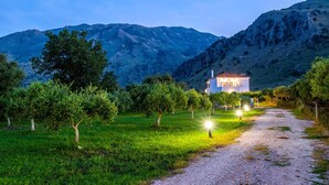 A house with a gravel path leading to it, surrounded by trees and mountains in the background. - Kournas-sleeps8-parking-garden-pool-petfriendly (Apokoronas)