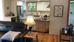A modern kitchen with white cabinets, a stainless steel refrigerator, and a window above the sink. - Located in beautiful/historic downtown Peninsula in the heart of a National Park (Peninsula)