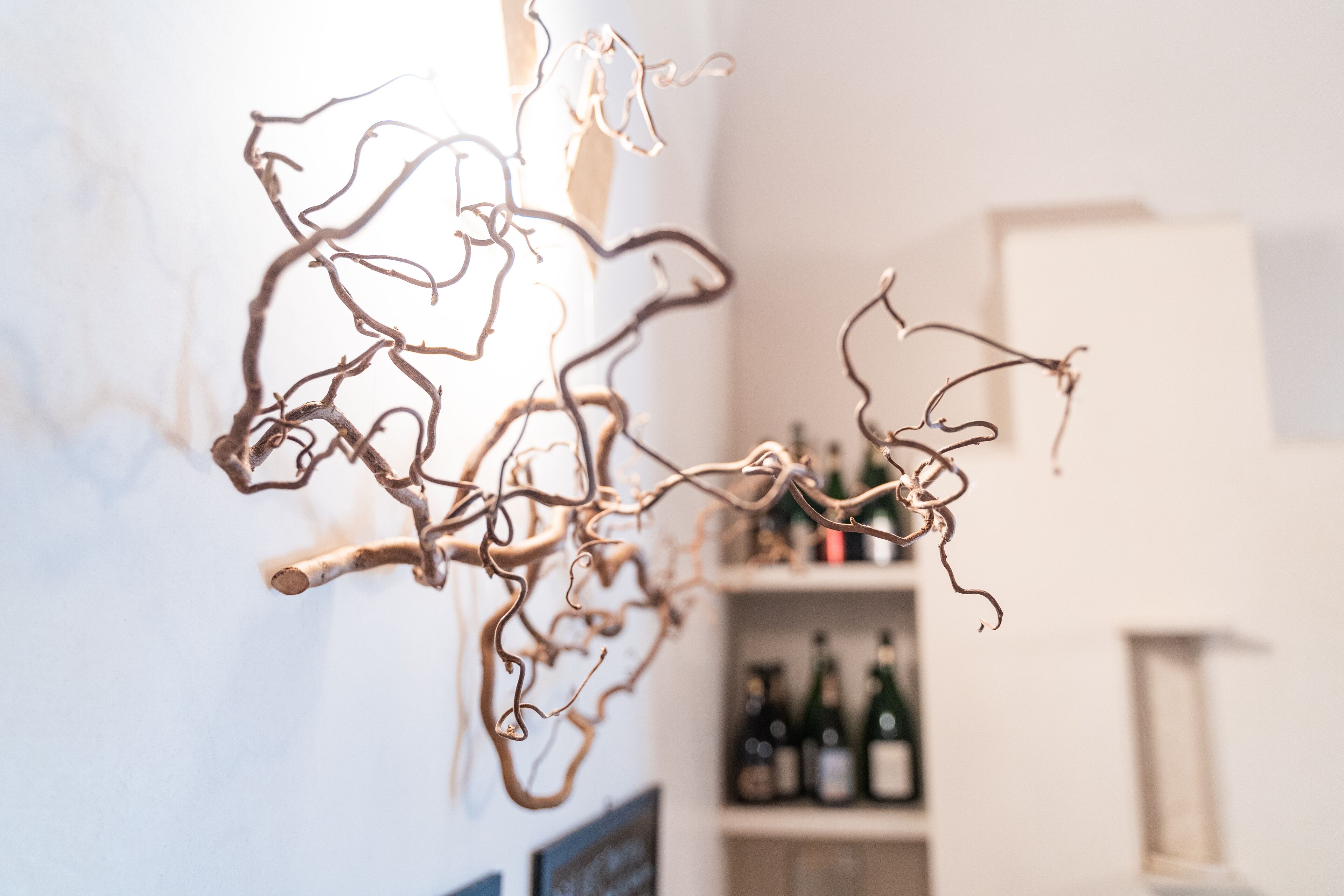 A room with a white wall and a shelf with bottles.