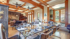 A spacious dining area with a large glass table, multiple chairs, and a ceiling fan. - Luxe & Stylish Santa Fe Home Rental Near Downtown! (Santa Fe)