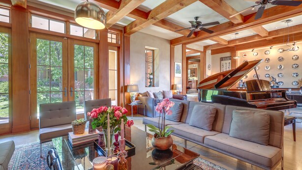 A spacious living room with a grand piano, a sofa, and a coffee table with decorative items. - Luxe & Stylish Santa Fe Home Rental Near Downtown! (Santa Fe)