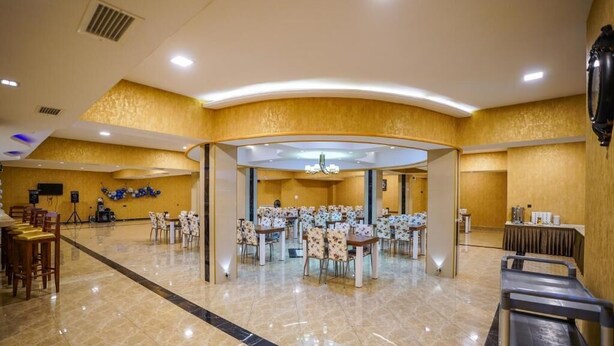 A spacious hotel lobby with a central seating area, a reception desk, and a buffet setup. - Natali Hotel (Borjomi)