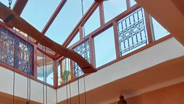 A spacious interior with high ceilings, a skylight, and hanging light fixtures. - Riad L'ayinn in Marrakesh (Marrakech)