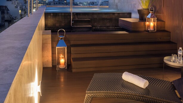 A rooftop terrace with a view of the city skyline, a wooden deck, and outdoor seating. - Casa Joseph (Buenos Aires)