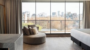 A modern bedroom with a large window, a round seating area, and a bed. - Casa Joseph (Buenos Aires)