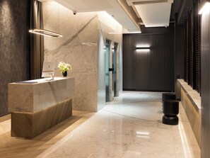 Welcome to our reception area, featuring a comfortable seating space with a reception desk and a potted plant.