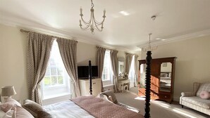 A bedroom with a four-poster bed, a dresser, a vanity, and a chaise lounge. - The Kedleston Country House (Derby)