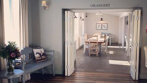 A room with a wooden floor, a bench, a table, and a door labeled "ORANGERY". - The Kedleston Country House (Derby)