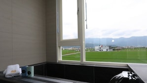 A bathroom with a large window, a towel, and a cup on the counter. - Wunuan ZOO Family Homestay (Jiaoxi)