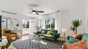 Una sala de estar moderna con un sofá verde, una mesa de centro y un ventilador de techo.