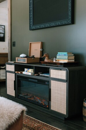 A vintage-style entertainment center with a record player, books, and decorative items. - Four-Season Luxury Lakefront Cabin Close to Camden and Rockland (Hope)