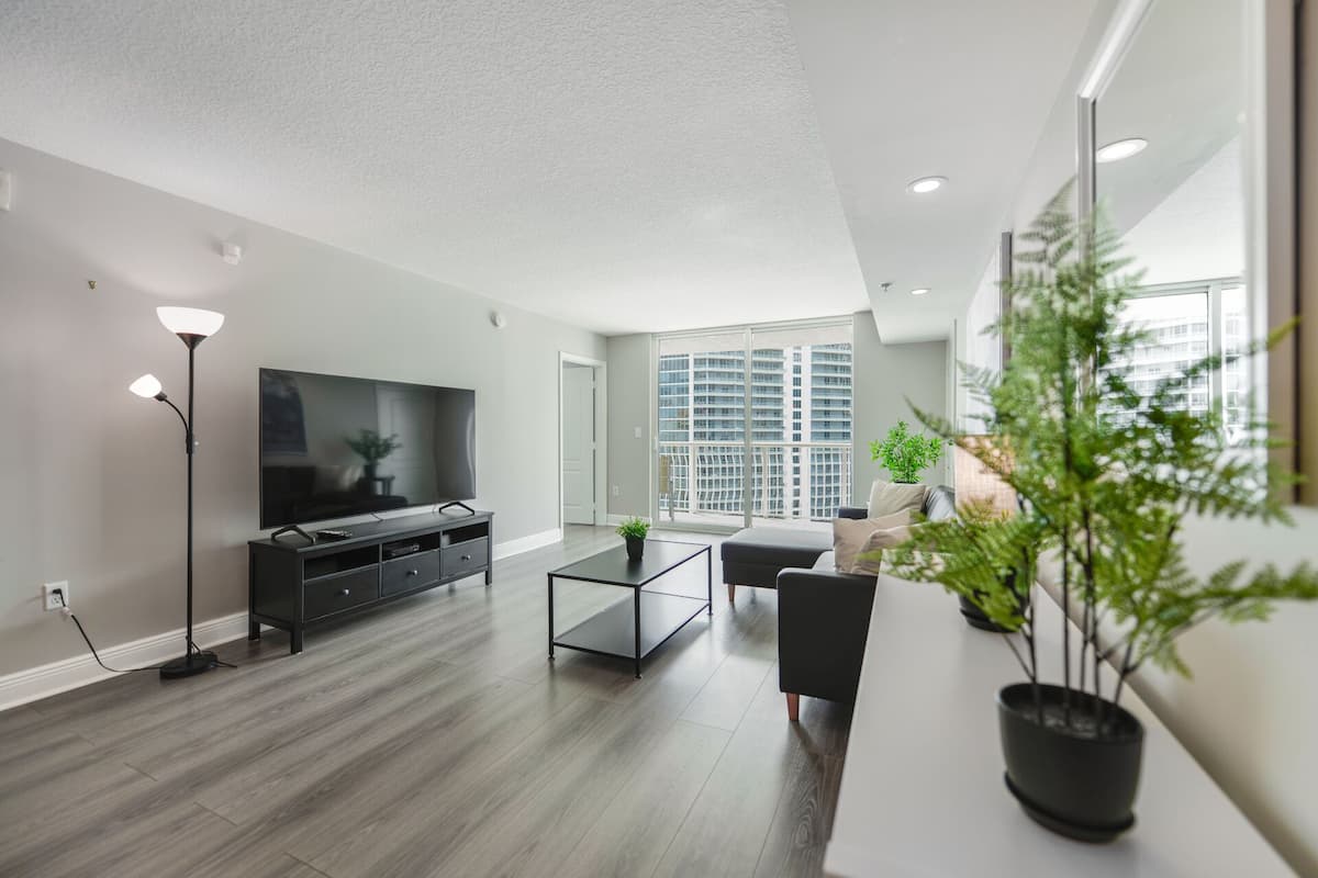 A modern living room with a flat-screen TV, a coffee table, and a sofa.