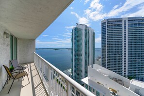 A balcony with a view of tall buildings and a body of water. - The Club at Brickell Bay (Miami)