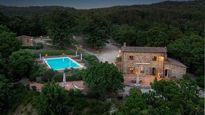 A stone building with a swimming pool surrounded by lush greenery. - Podere Santa Croce 10, Emma Villas (Radicondoli)