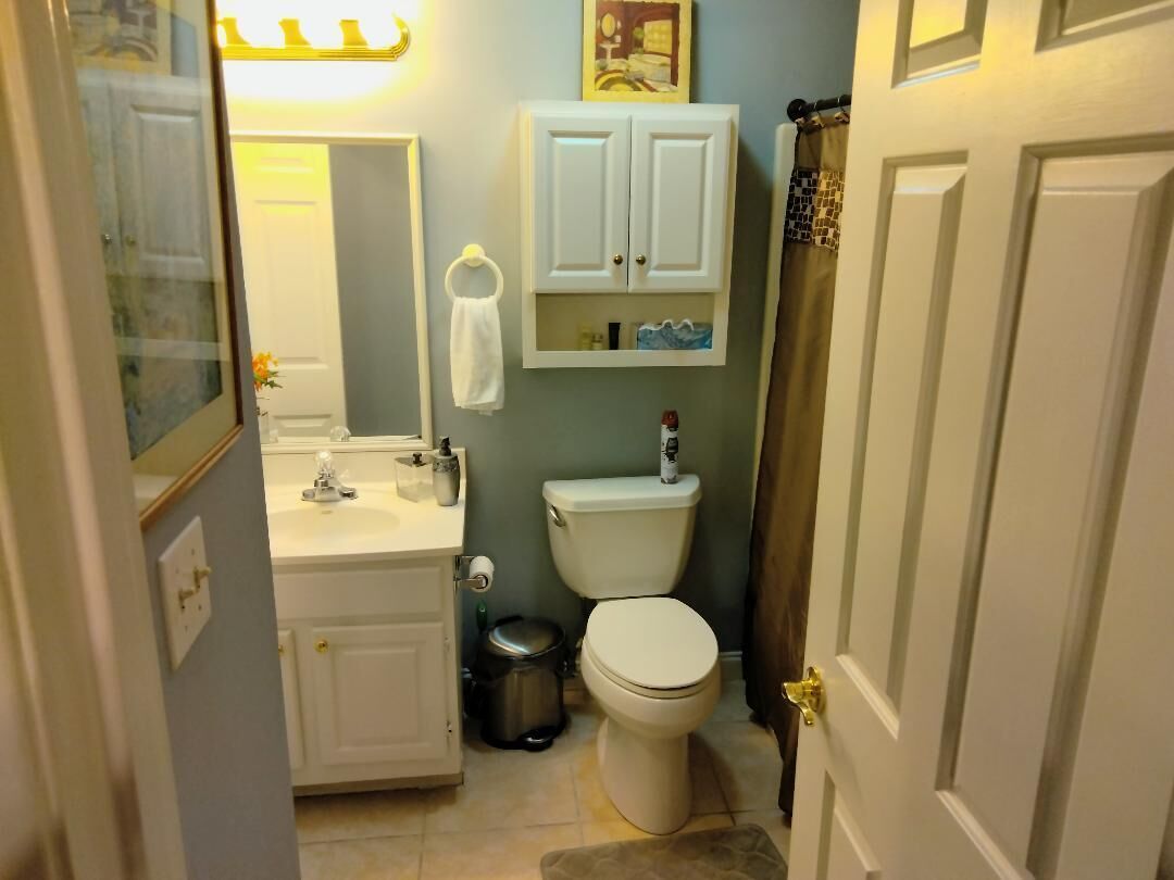 Een kleine badkamer met toilet, wastafel en kastje.
