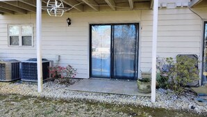 A house with a covered porch, a sliding glass door, and two air conditioning units. - Unique 2 BR, 2 Bath Condo in Surfside Beach, SC;  Central Grand Strand (Surfside Beach)