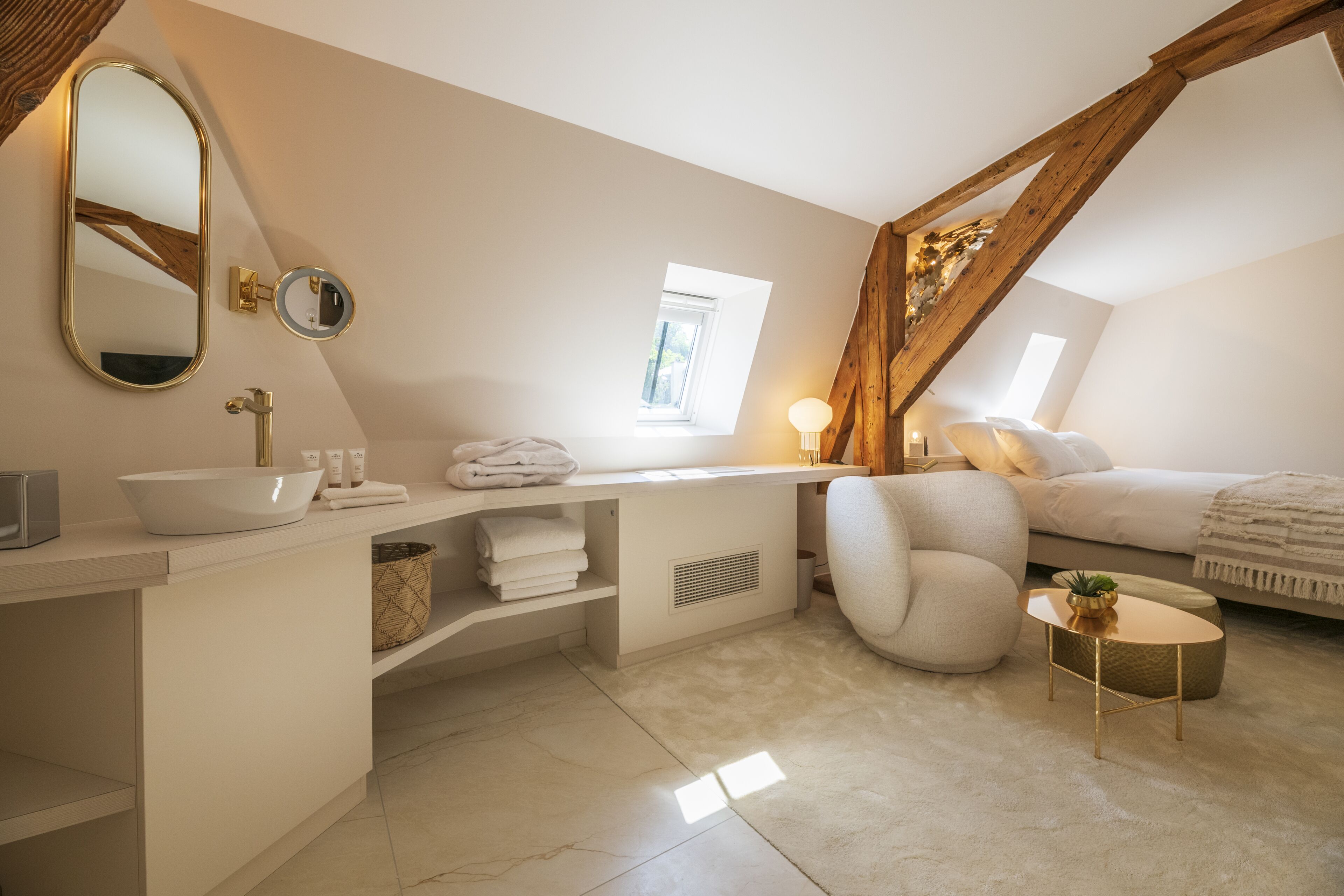 Una camera da letto moderna con una grande finestra, una toeletta bianca con specchio, un comodino e un letto confortevole.