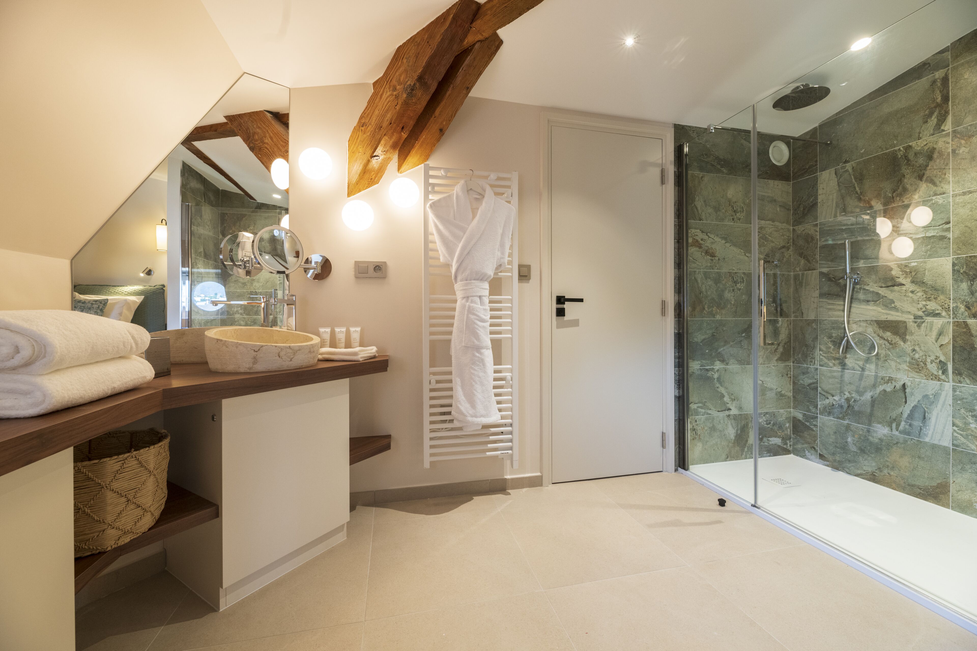 Une salle de bain moderne avec une douche en verre, un meuble-lavabo en bois et un porte-serviettes.