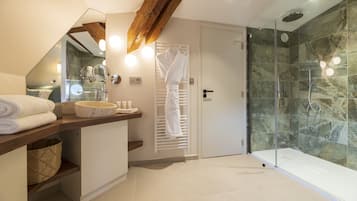 Une salle de bain moderne avec une douche en verre, un meuble-lavabo en bois et un porte-serviettes.
