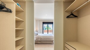 A bedroom with a bed, a closet with shelves, and a window with a view. - Jardiana Lotus | Walking distance to La Cala De Mijas (La Cala de Mijas)