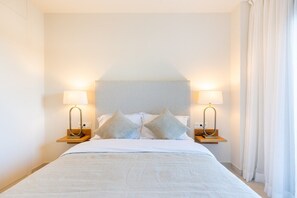 Ett hotellrum med en säng, två sänglampor och en sänggavel.