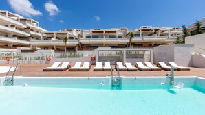A swimming pool with sun loungers and a view of multi-story buildings. - Jardiana Lotus | Walking distance to La Cala De Mijas (La Cala de Mijas)