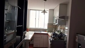 A compact kitchen with a central island, a sink, and a stove.