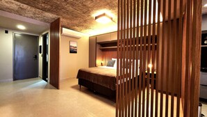 Ein Schlafzimmer mit Bett, Nachttisch und Wandklimaanlage.