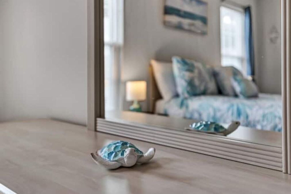 A bedroom with a bed, pillows, and a small turtle figurine on a bedside table.