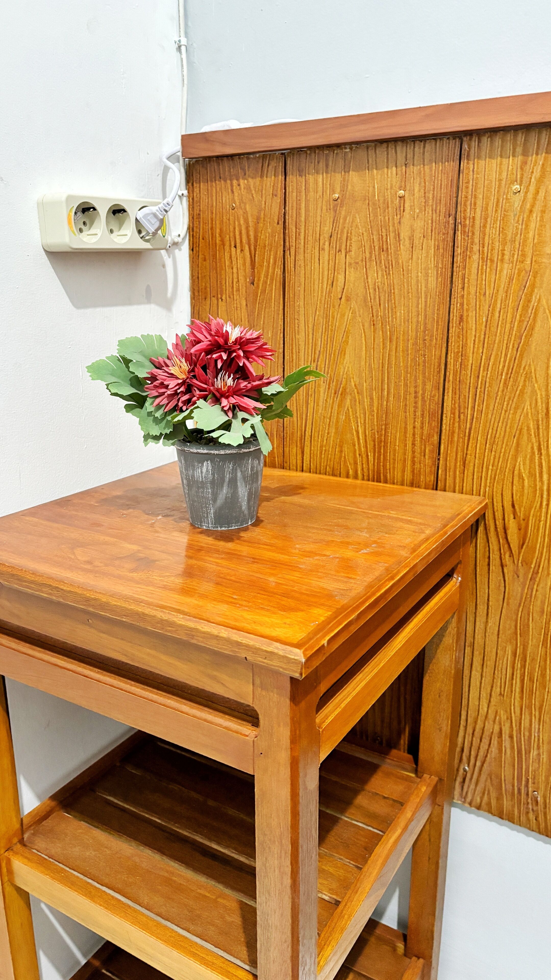 Una mesa de madera con una maceta encima.