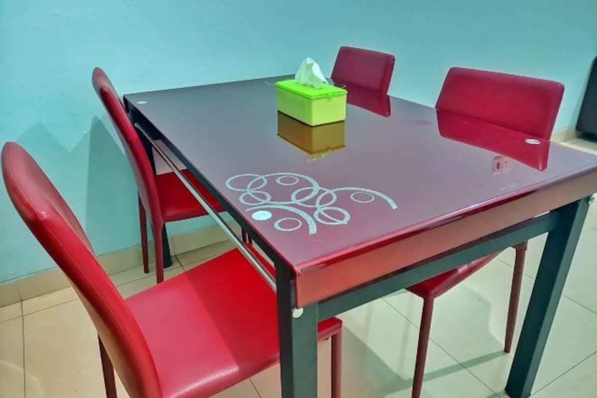 A dining table with a green tissue box and a red chair.