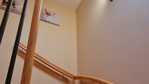 A wooden staircase with a handrail and a light fixture above. - Gîte le Fortunio-Gîte-Family-Ensuite with Bath (RIEUTORT DE RANDON)