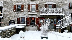 A stone building with a sign reading 'LE FORTUNIO' and a staircase leading to a balcony. - Gîte le Fortunio-Gîte-Family-Ensuite with Bath (RIEUTORT DE RANDON)