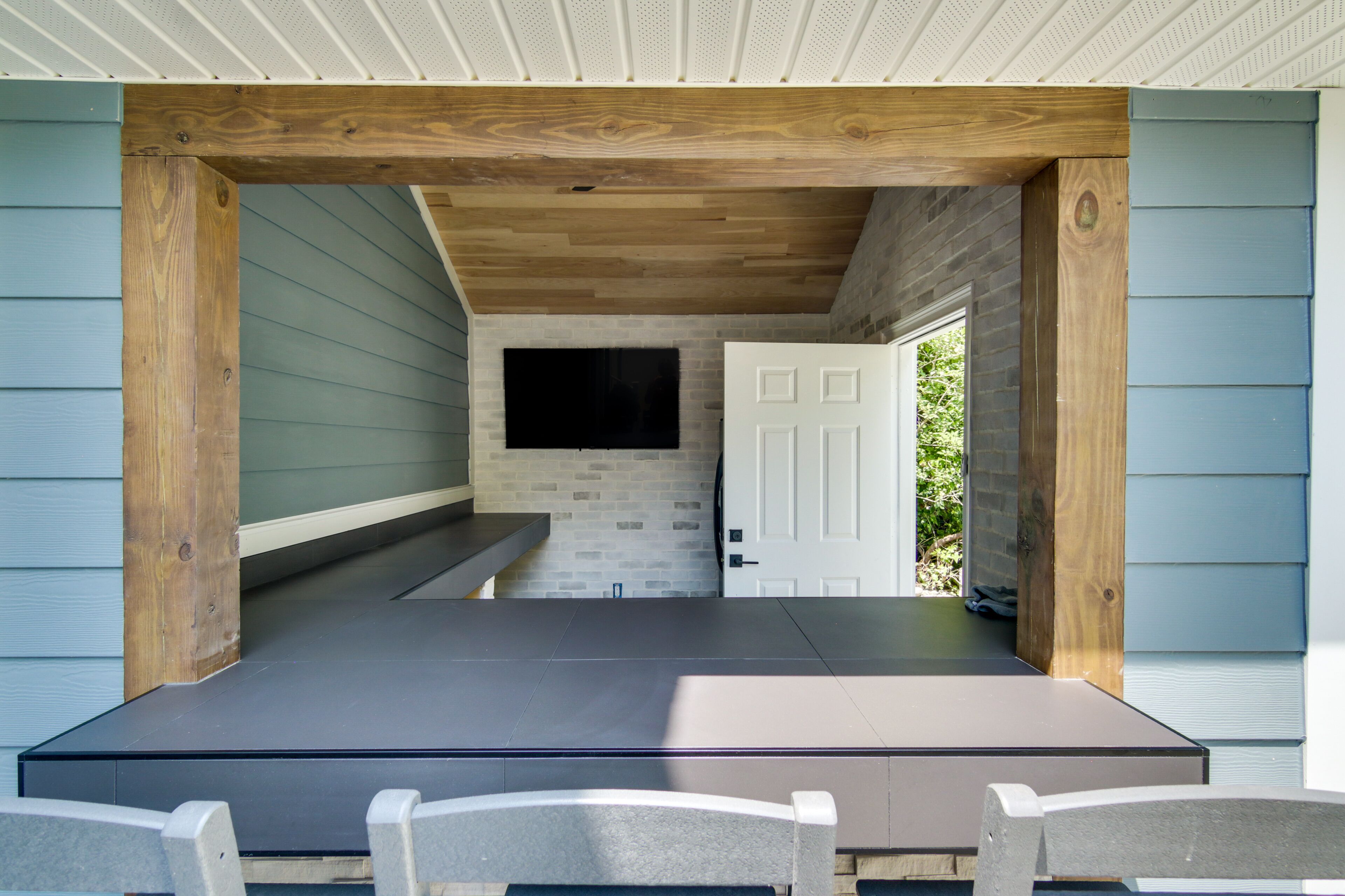An outdoor seating area with a wooden bench and a flat surface, likely for dining or events.