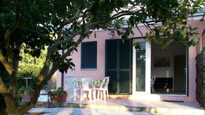 Une maison dotée d’un patio, d’un espace salon extérieur et d’un téléviseur dans le salon.
