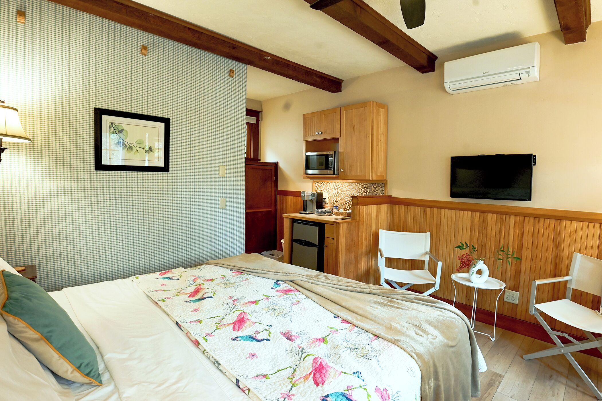 Une chambre avec un lit, un bureau doté d’un micro-ondes, une télévision et une petite kitchenette.