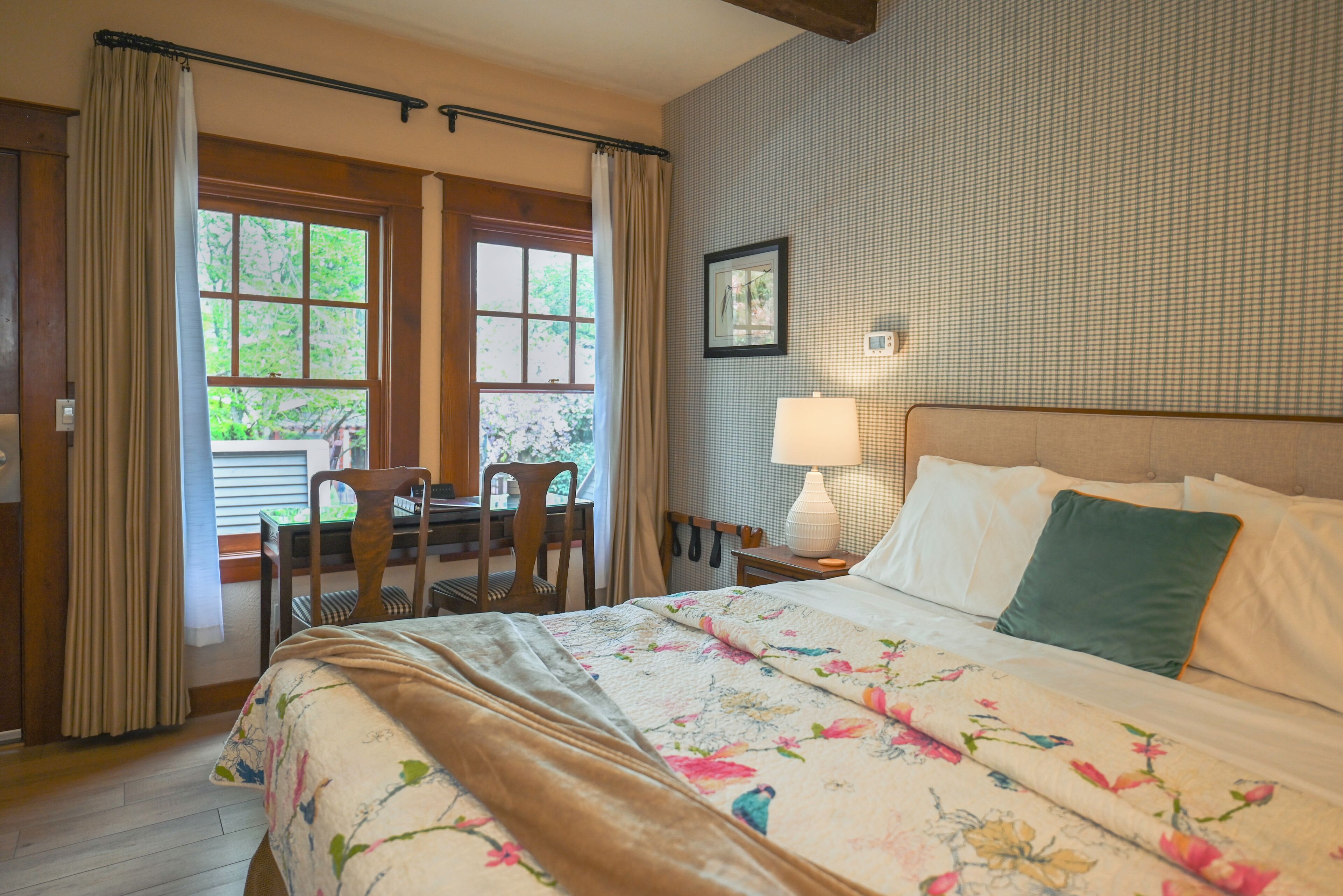 A bedroom with a bed, a desk, and a chair.