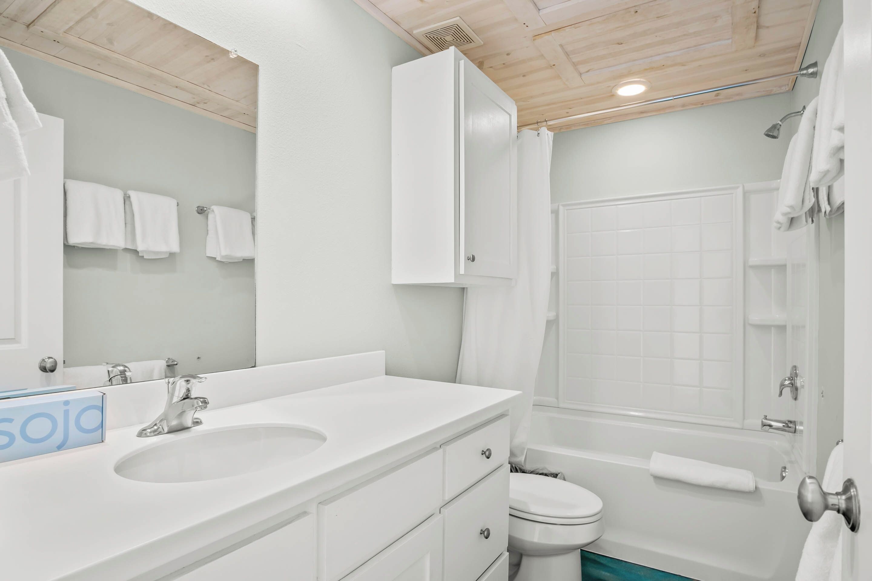 Ein Badezimmer mit Waschbecken, Spiegel und Schrank, Toilette und Badewanne.