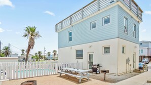 A two-story building with a pool, picnic table, and barbecue grill. - 7 Heaven by Silver Sands Vacation Rentals (Port Aransas)