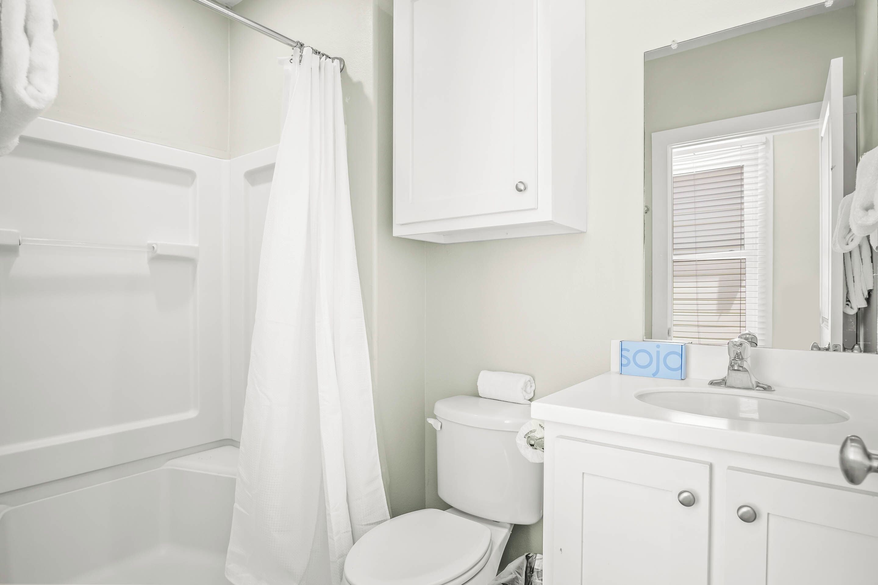A bathroom with a bathtub, toilet, and sink.