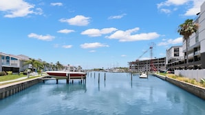 Ein Kanal mit vor Anker liegenden Booten, moderne Gebäude und ein klarer Himmel.