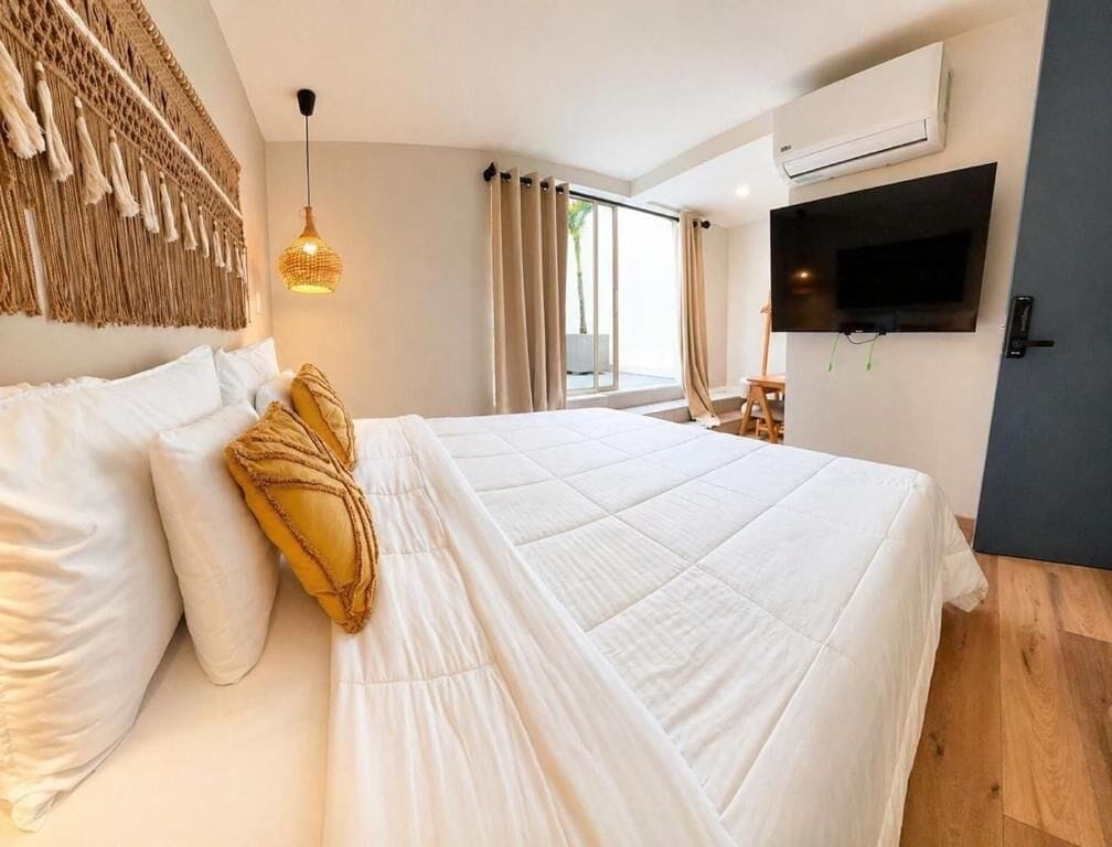 Une chambre d’hôtel avec un lit, une télévision et une grande fenêtre.