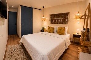 Ein Schlafzimmer mit einem Bett, Nachttischen, einem Fernseher und einer Wandleuchte.