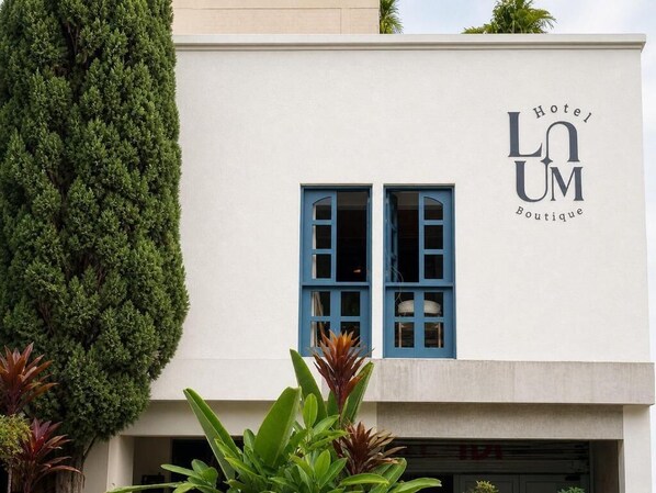 A building with a sign that reads 'Hotel LUM Boutique' and two blue-framed windows. - Luum Boutique Hotel (Medellín)