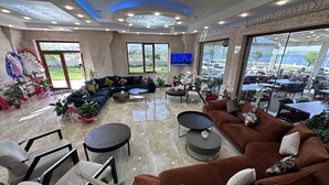 A spacious lounge area with a large sectional sofa, multiple seating options, and a television. - Beyaz Köşk Hotel & Cafe (Tatvan)