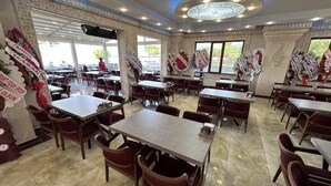 A restaurant with marble flooring, red upholstered chairs, and tables. - Beyaz Köşk Hotel & Cafe (Tatvan)