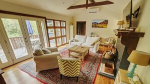 A spacious living room with a sofa, armchair, coffee table, and a fireplace. - Rivers Breeze - Wine Tastings Included (Healdsburg)