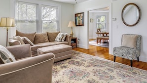 A living room with a beige sofa, a patterned rug, and a zebra-print chair. - Beautiful Providence Apt Near Dtwn & Federal Hill! (Providence)