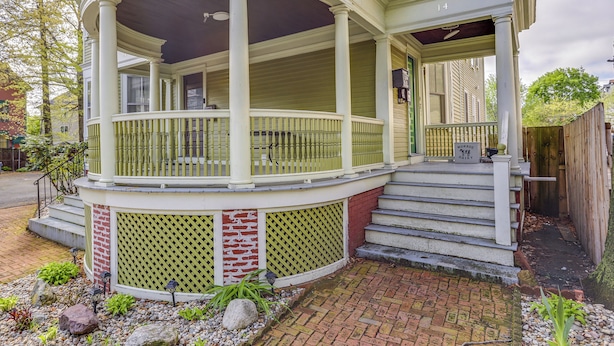 A two-story house with a covered porch, a brick foundation, and a wooden fence. - Beautiful Providence Apt Near Dtwn & Federal Hill! (Providence)