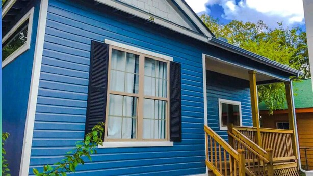 Ein blaues Haus mit Veranda und Treppe.
